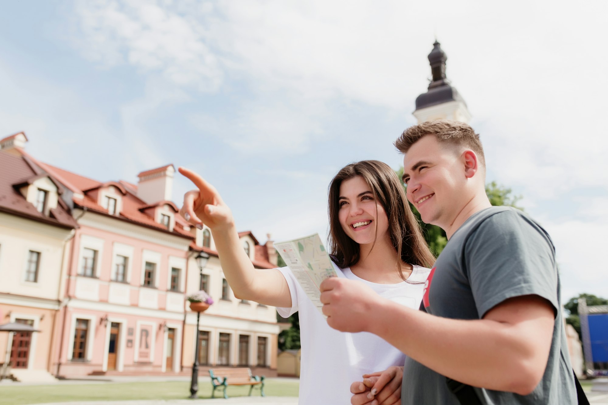 Couple of tourists in love looking at city map to understand how to find a place
