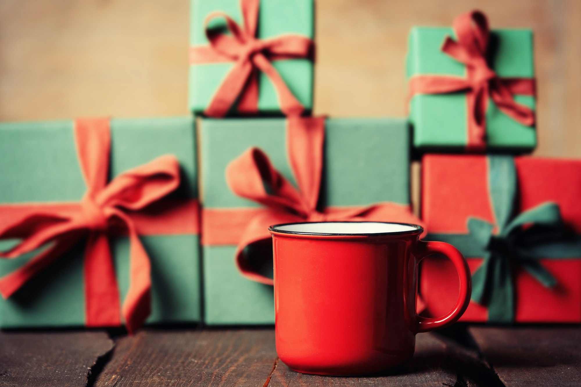 Cup of coffee and Holiday gifts on wooden table